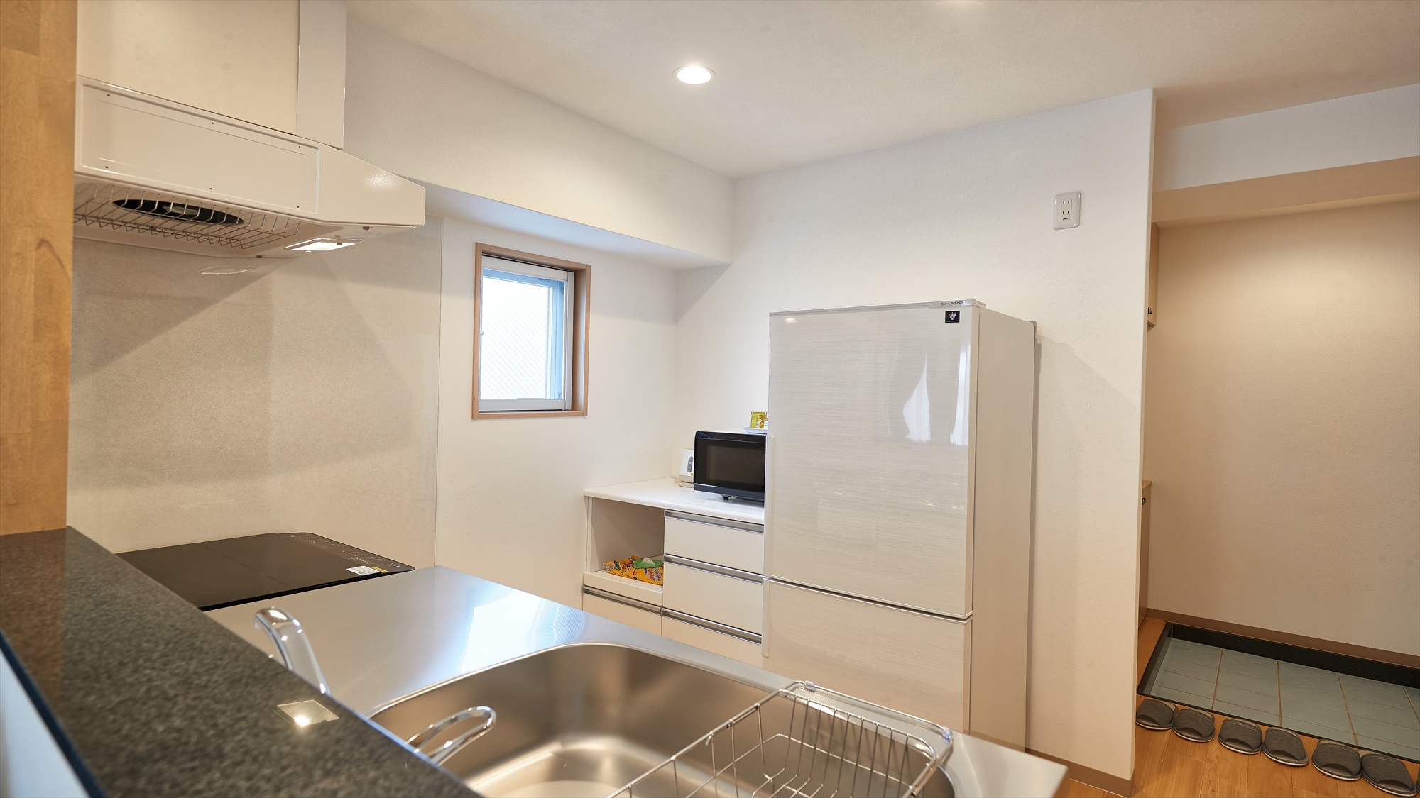 【クワッドルーム/キッチン】大型冷蔵庫と電子レンジ。長期滞在に必要な設備が揃っています。