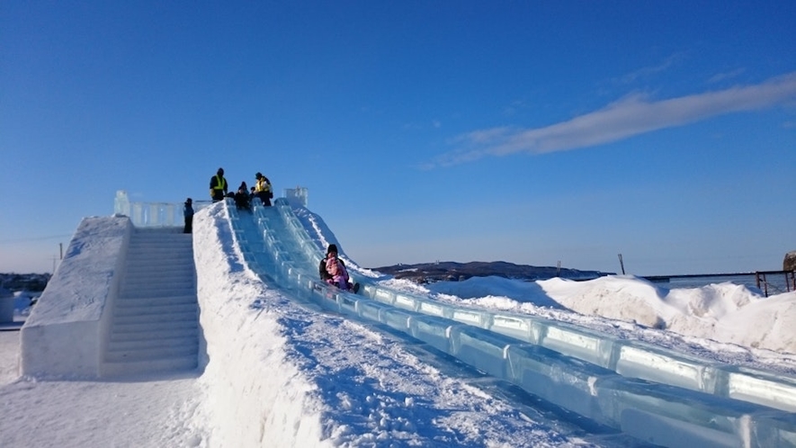 氷の滑り台で楽しむ子どもたち