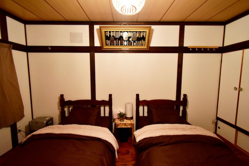 落ち着いた雰囲気の1F寝室。シングルベッド2つ 最大2名就寝可能