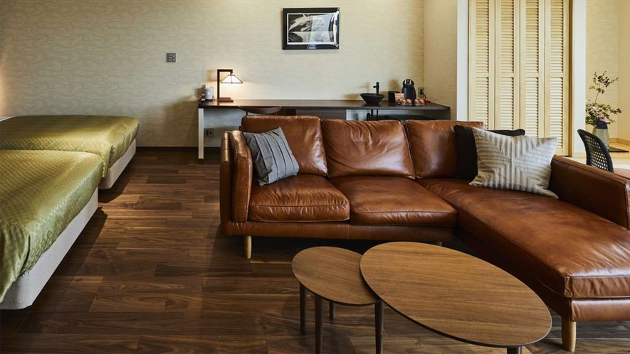ウォールナットの床材に、茶色のレザーソファーが特徴のお部屋です。