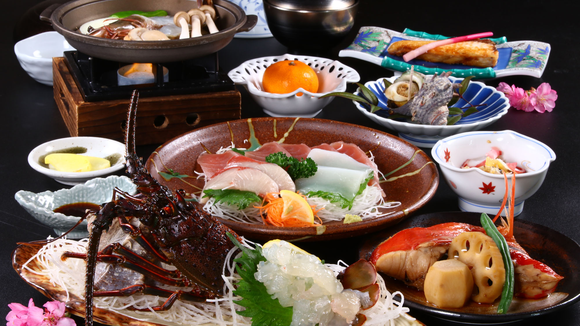 源兵屋の夕食。伊勢海老とあわび、金目鯛の三大味覚が並ぶ