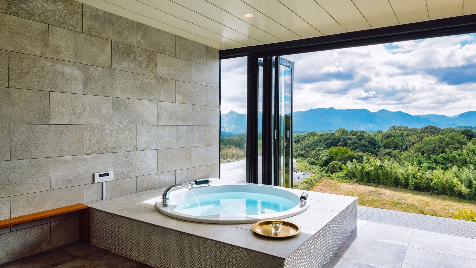ジャグジー半露天風呂。大きな窓から、九重連山を眺めながらお寛ぎいただけます。