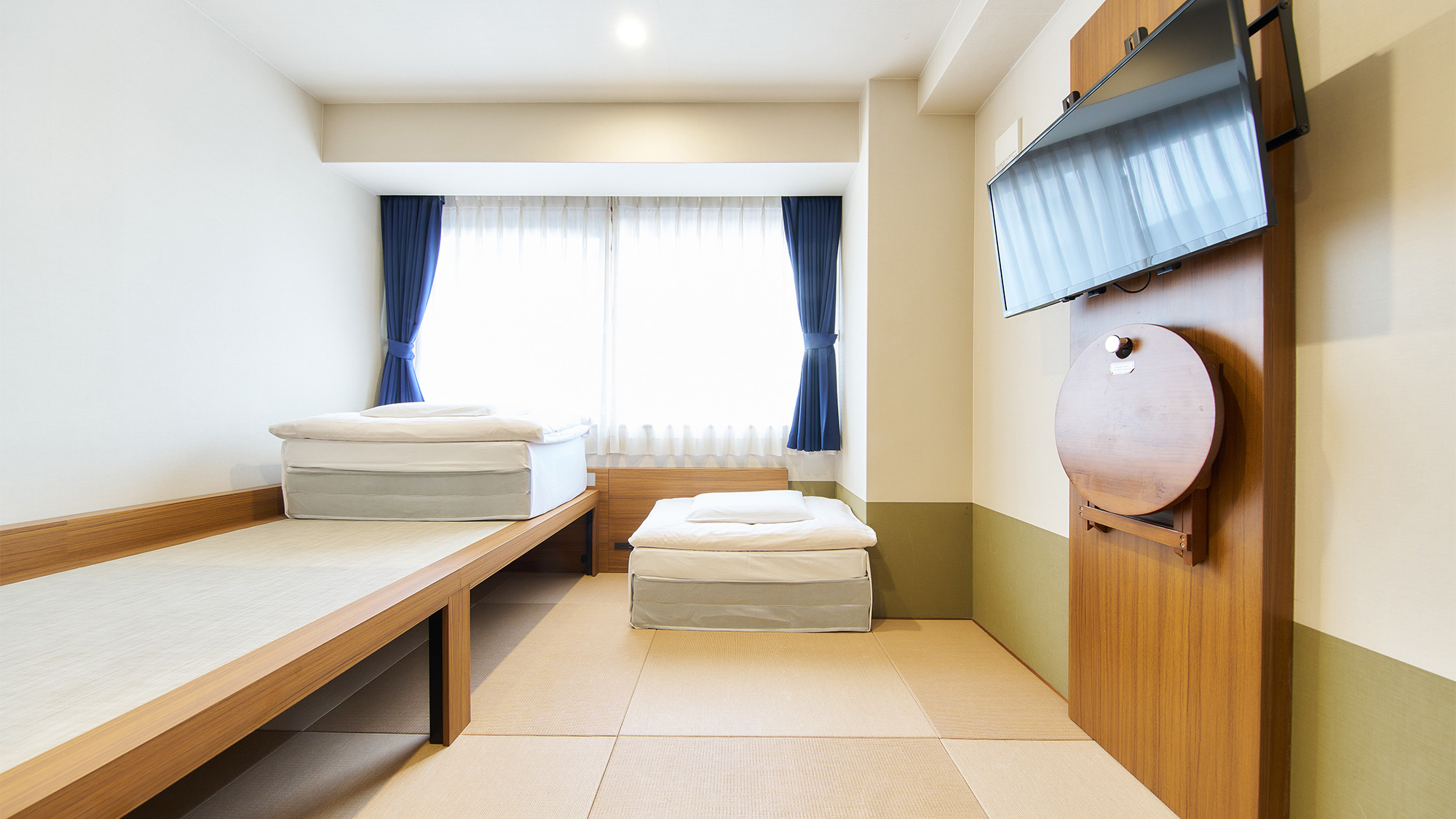 ・【ツインルーム】自然光の差し込む明るいお部屋です。テレビの下に折り畳みテーブルもございます