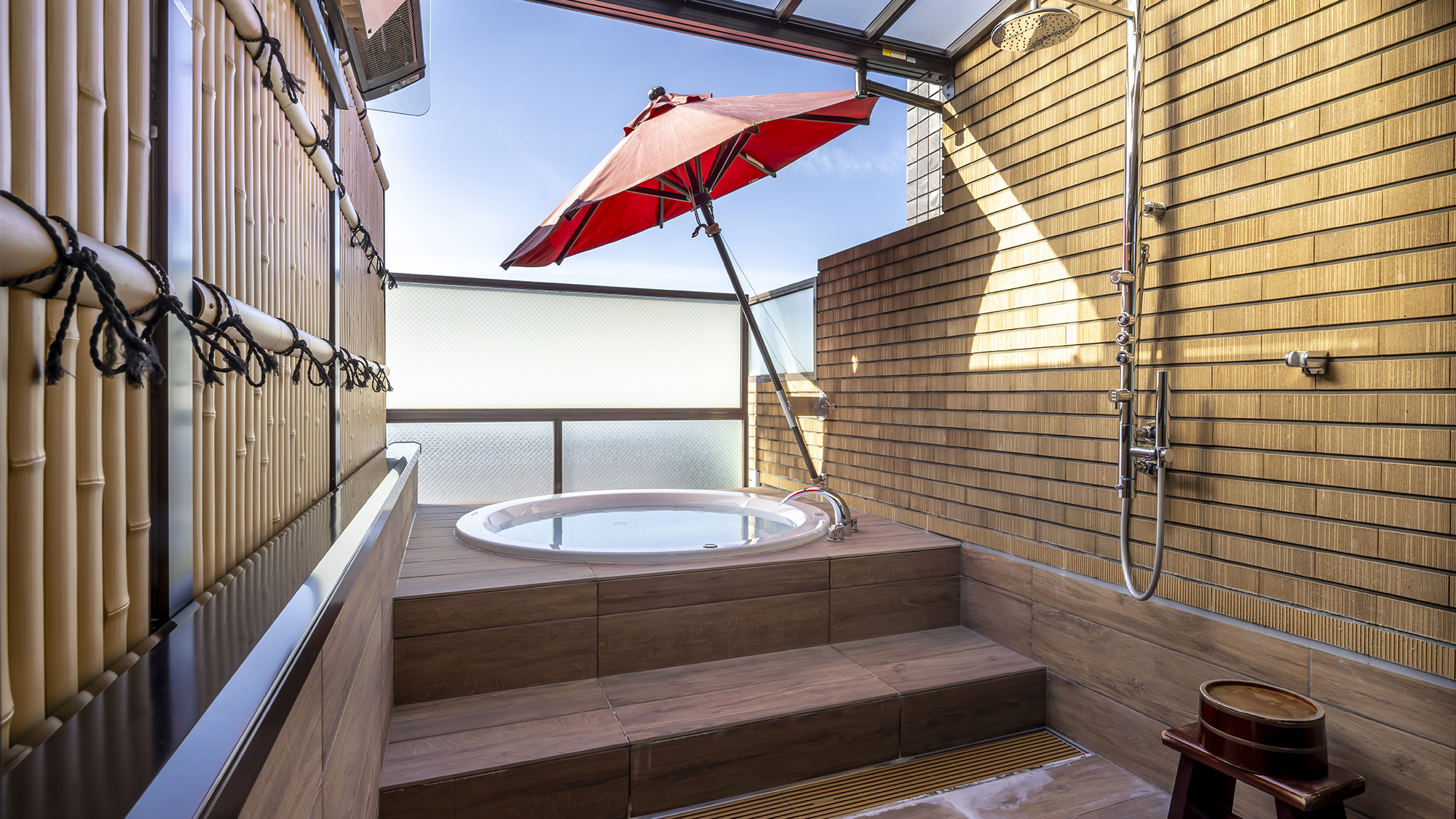 《デラックスツインA》当館唯一の露天風呂。赤い野点傘付きの大きなバスタブでゆっくりとお寛ぎください。
