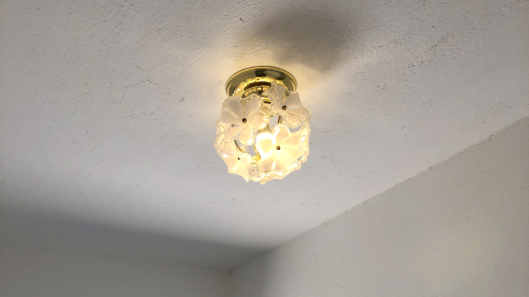 ・【エントランス】花をあしらった個性的なランプシェードが空間のアクセントに