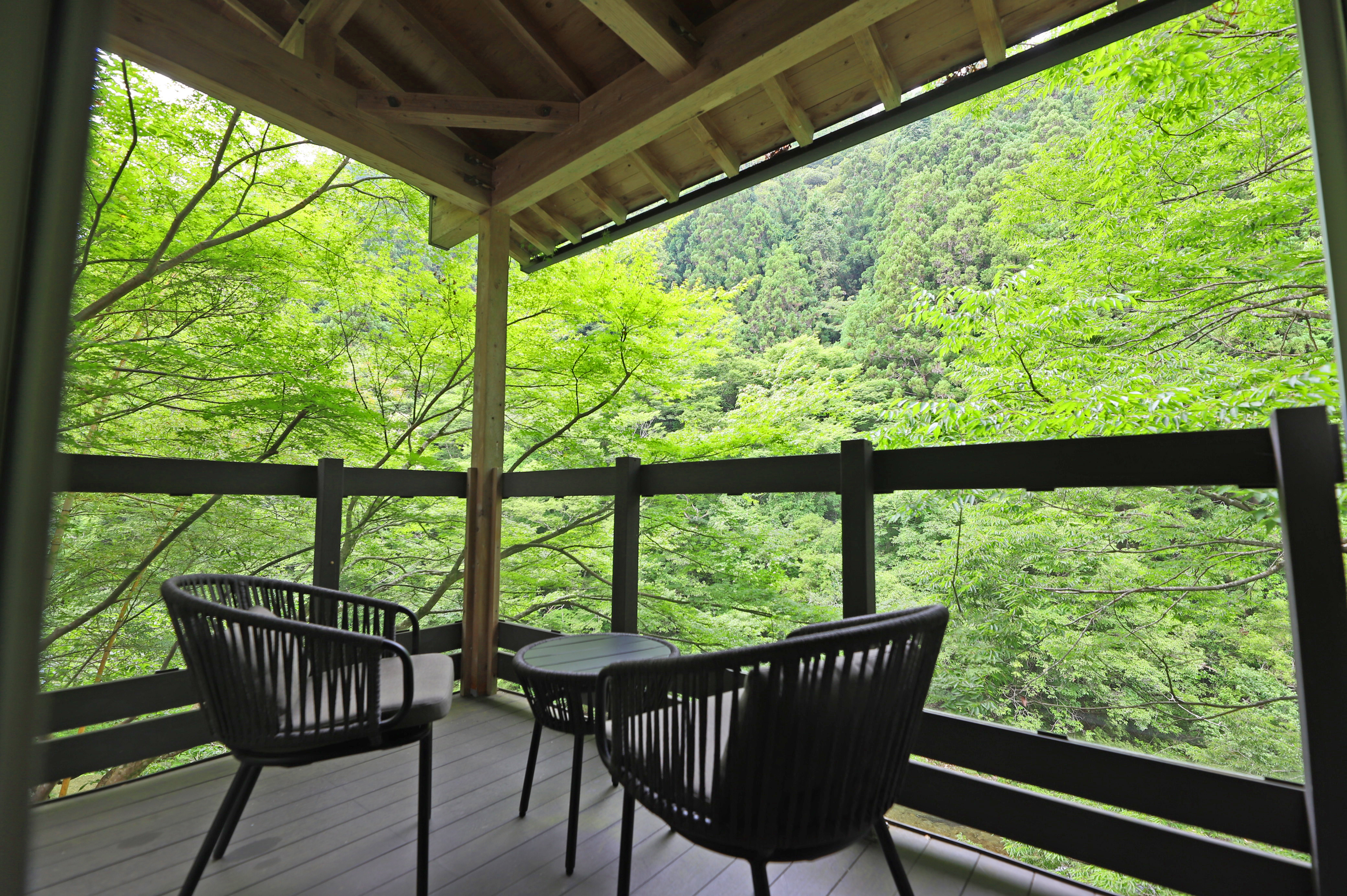 内風呂付き特別室のテラス席。川のせせらぎと緑にすっぽり包まれる。