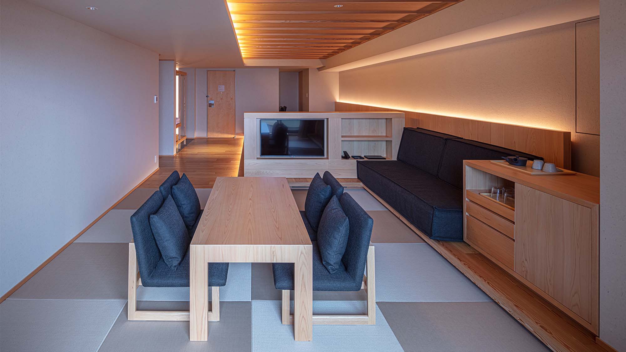 【プレミアムスイート】62㎡／ベッド幅1,200mm+ソファベッド　椅子とテーブルを備えた寛ぎ空間。