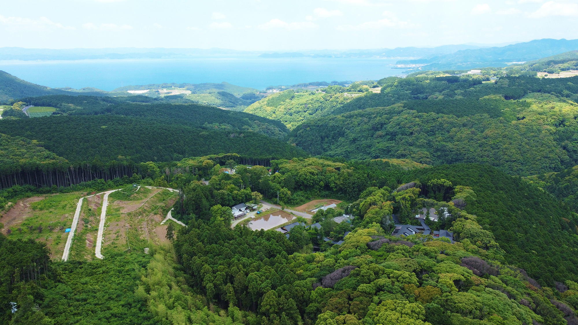 【施設上空】山だけでなく、海も眺められる風光明媚な地。美しい緑に心も癒されるひと時を