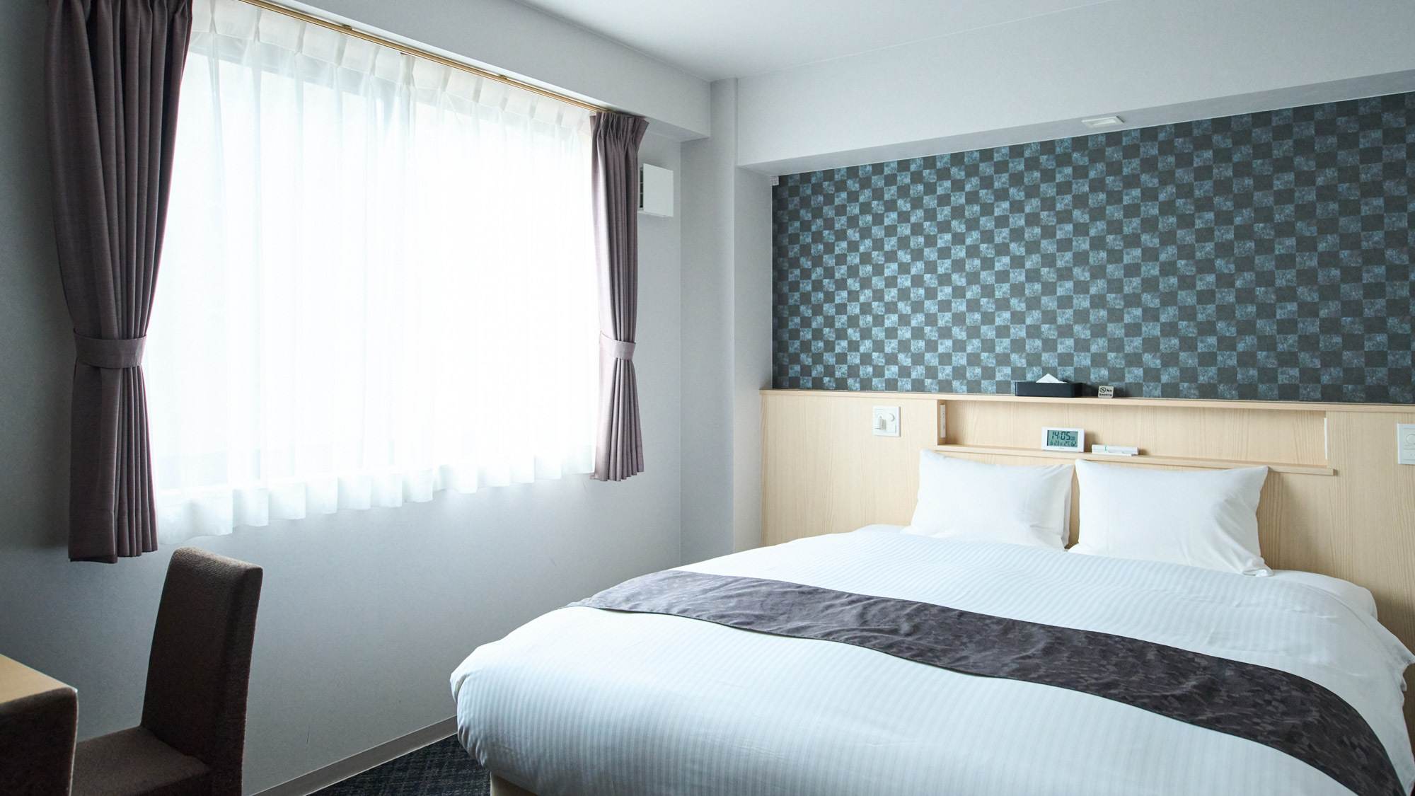 【クイーンルーム】クイーンサイズのベッドを設置したゆとりのある広さ。連泊の一人旅にも。