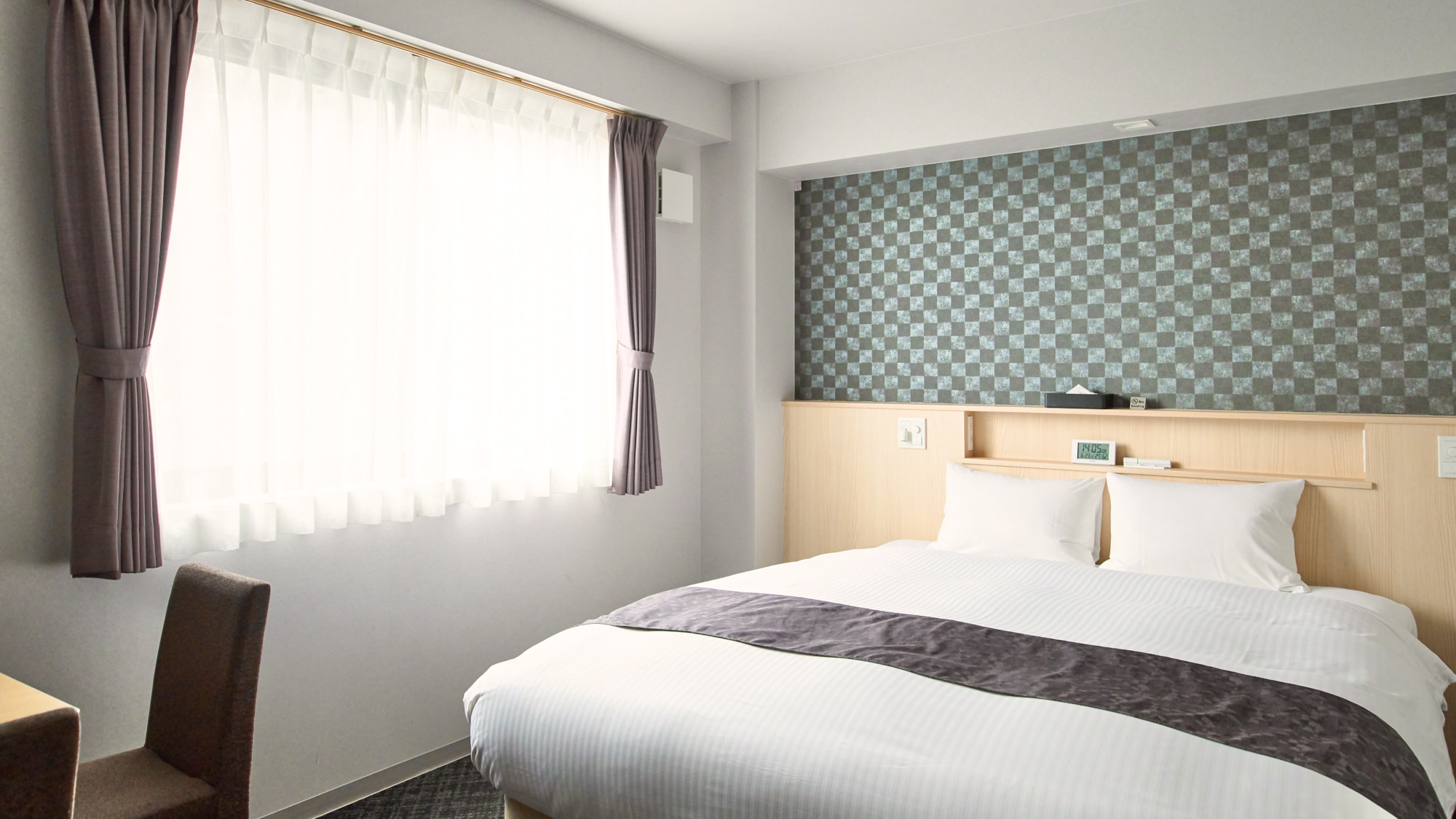 【クイーンルーム】クイーンサイズのベッドを設置したゆとりのある広さ。連泊の一人旅にも。