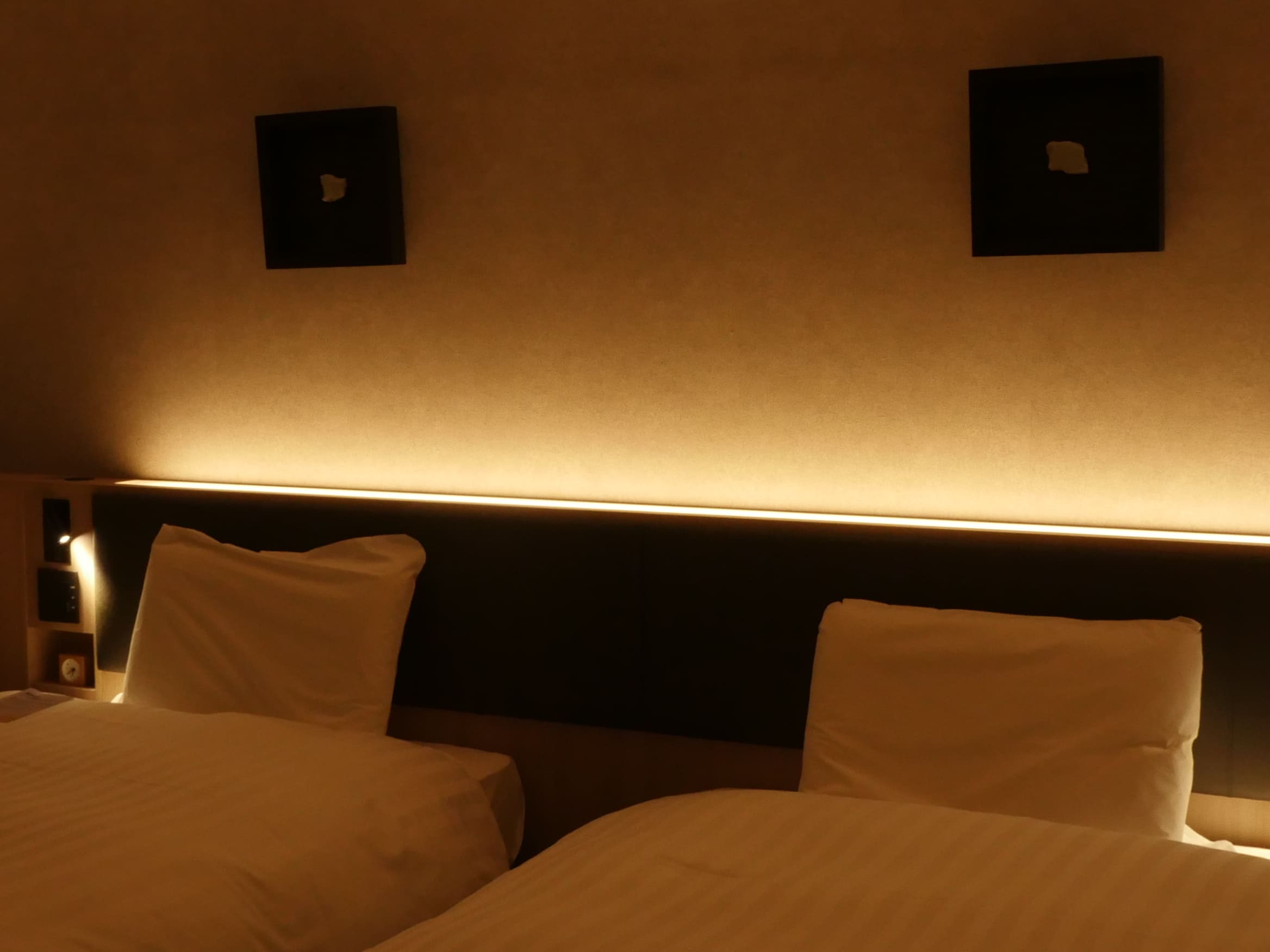 ツインのお部屋には壁を照らす間接照明を設置