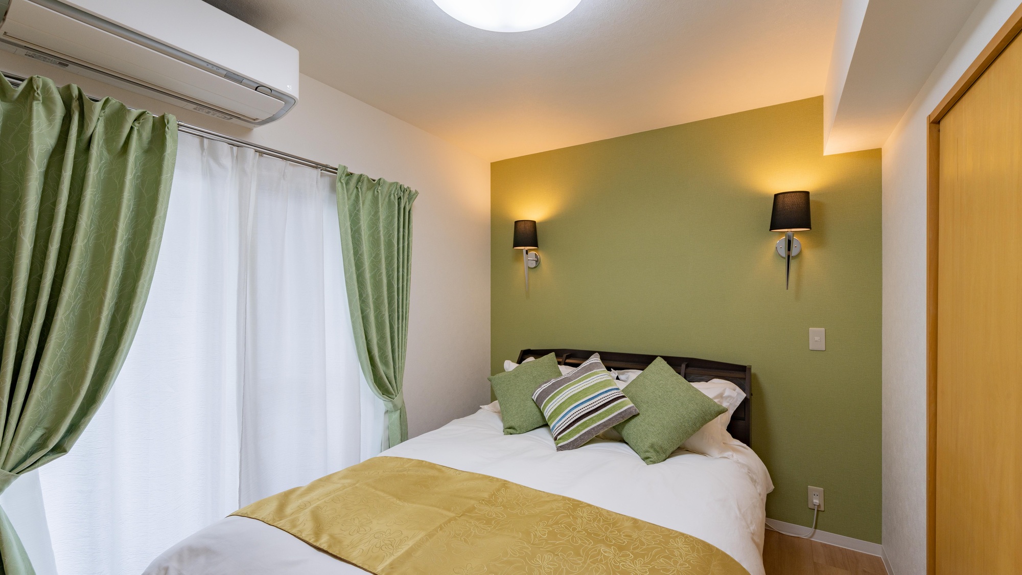 ・【ダイニング付き5名定員】ダブルベッドを設置。グリーンを基調にしたインテリア