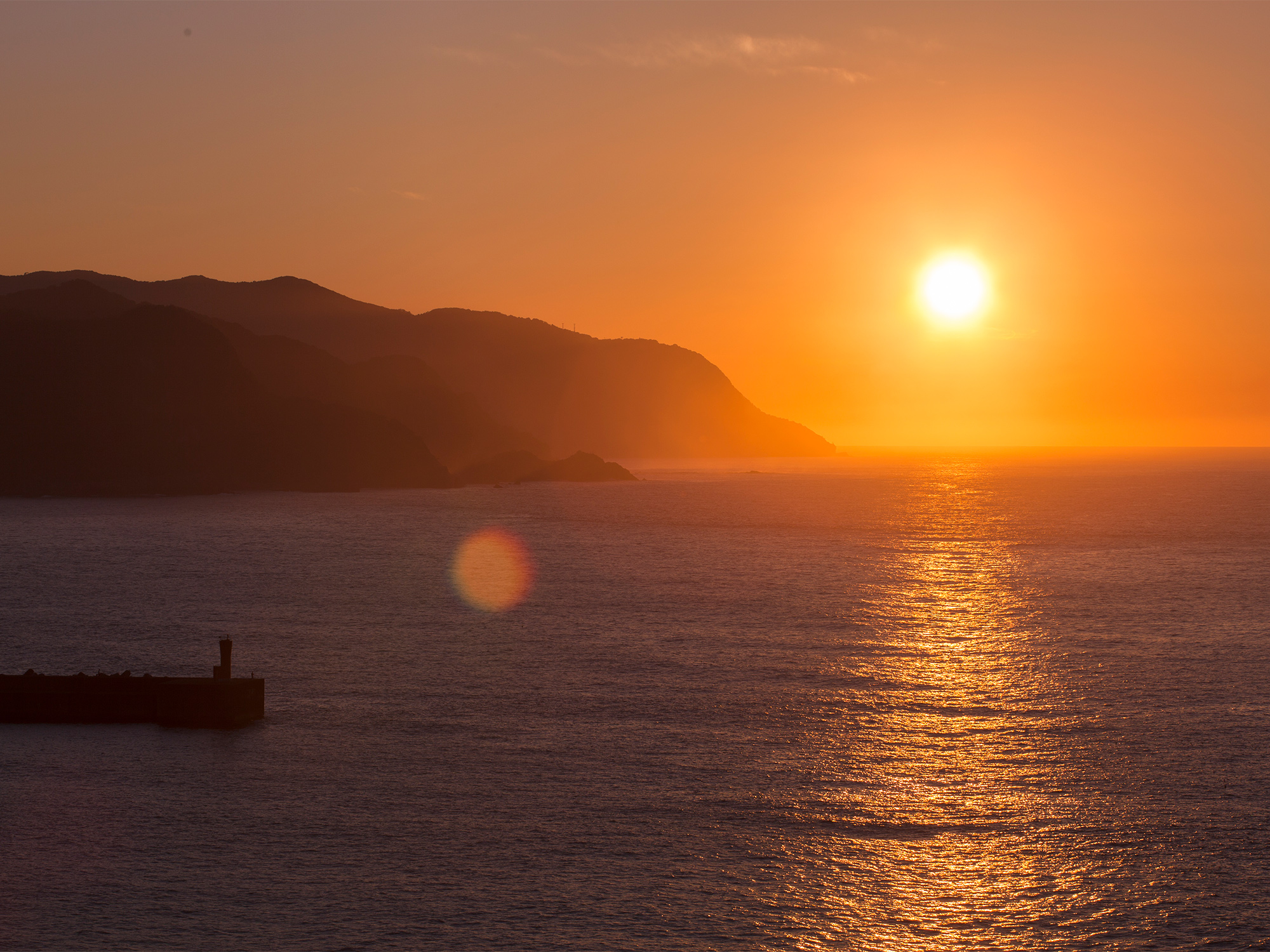 海に沈む夕日と海面に映る夕凪