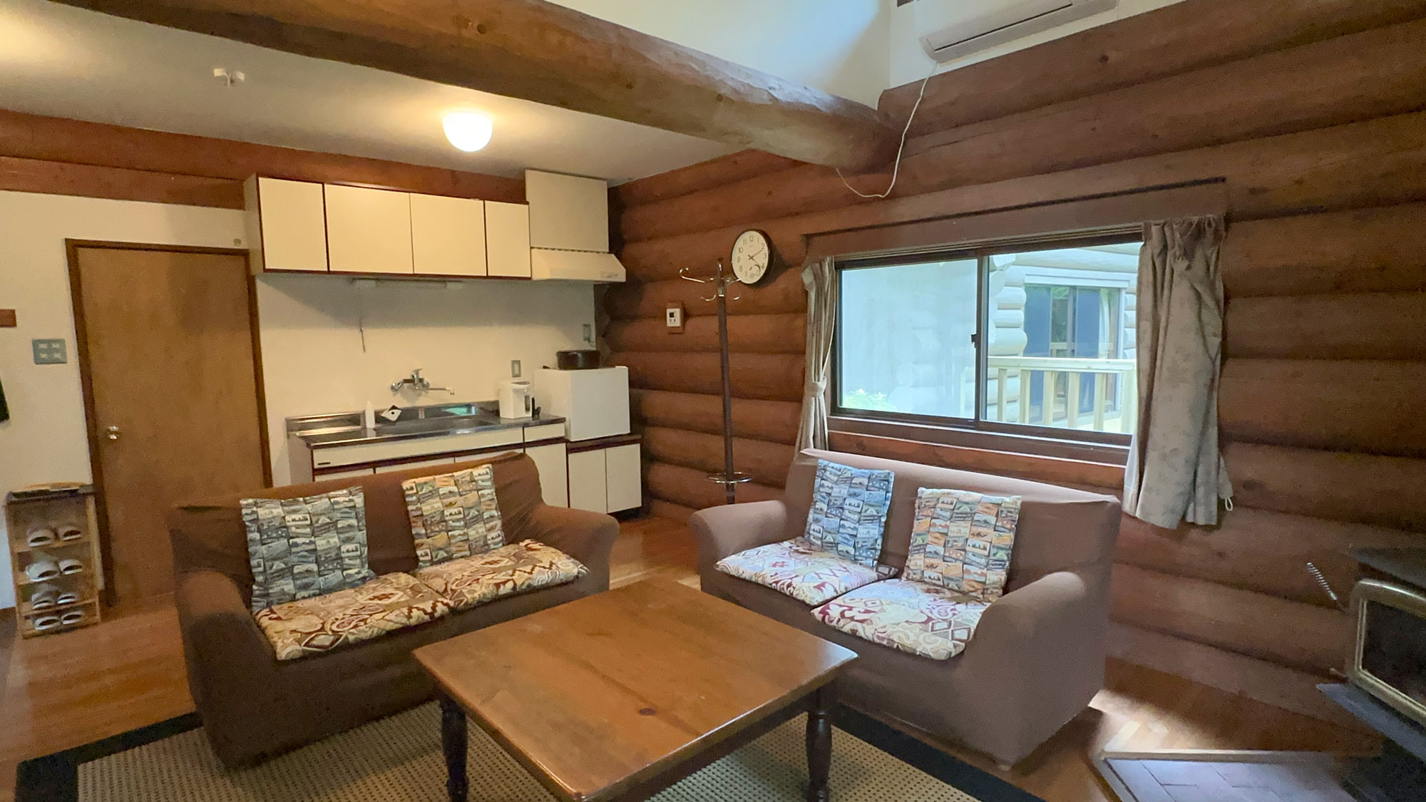 ログハウス風コテージ客室一例：木の温もりを感じるリビング。