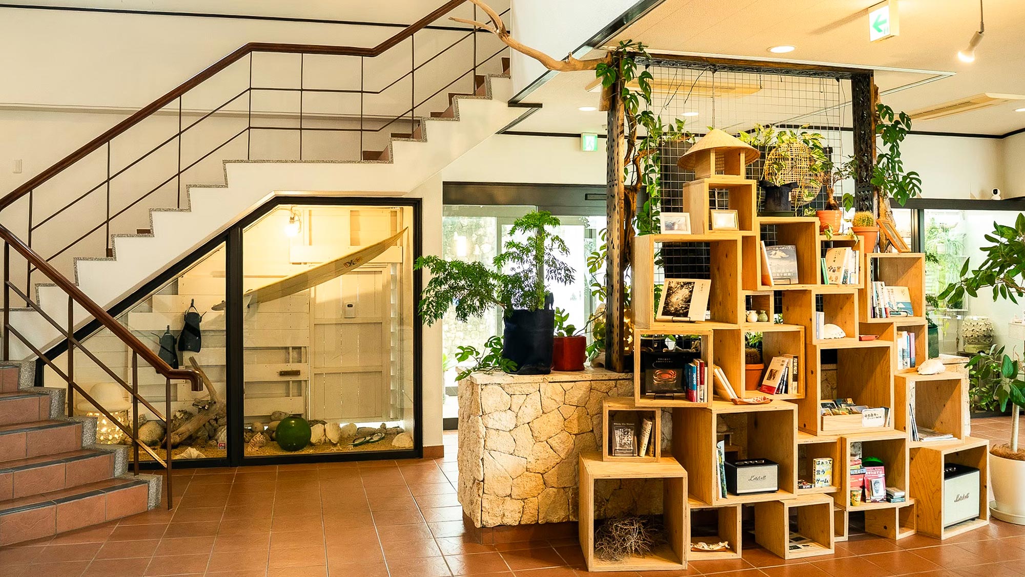 ・【ロビー】木製の本棚と緑あふれる植物が調和した、明るく落ち着いたロビー空間です