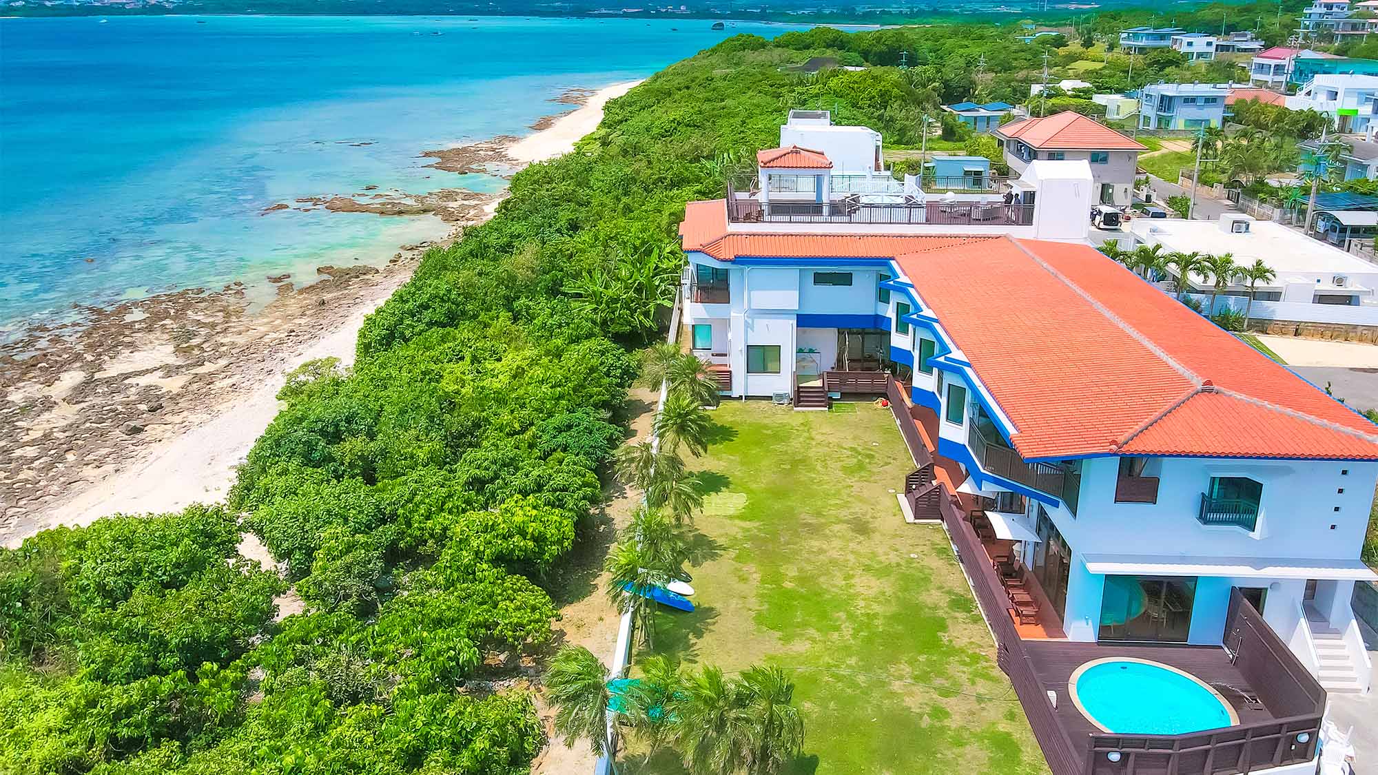 ・八重山椰子の並んだガーデンの先には透き通ったブルーの海が広がっています