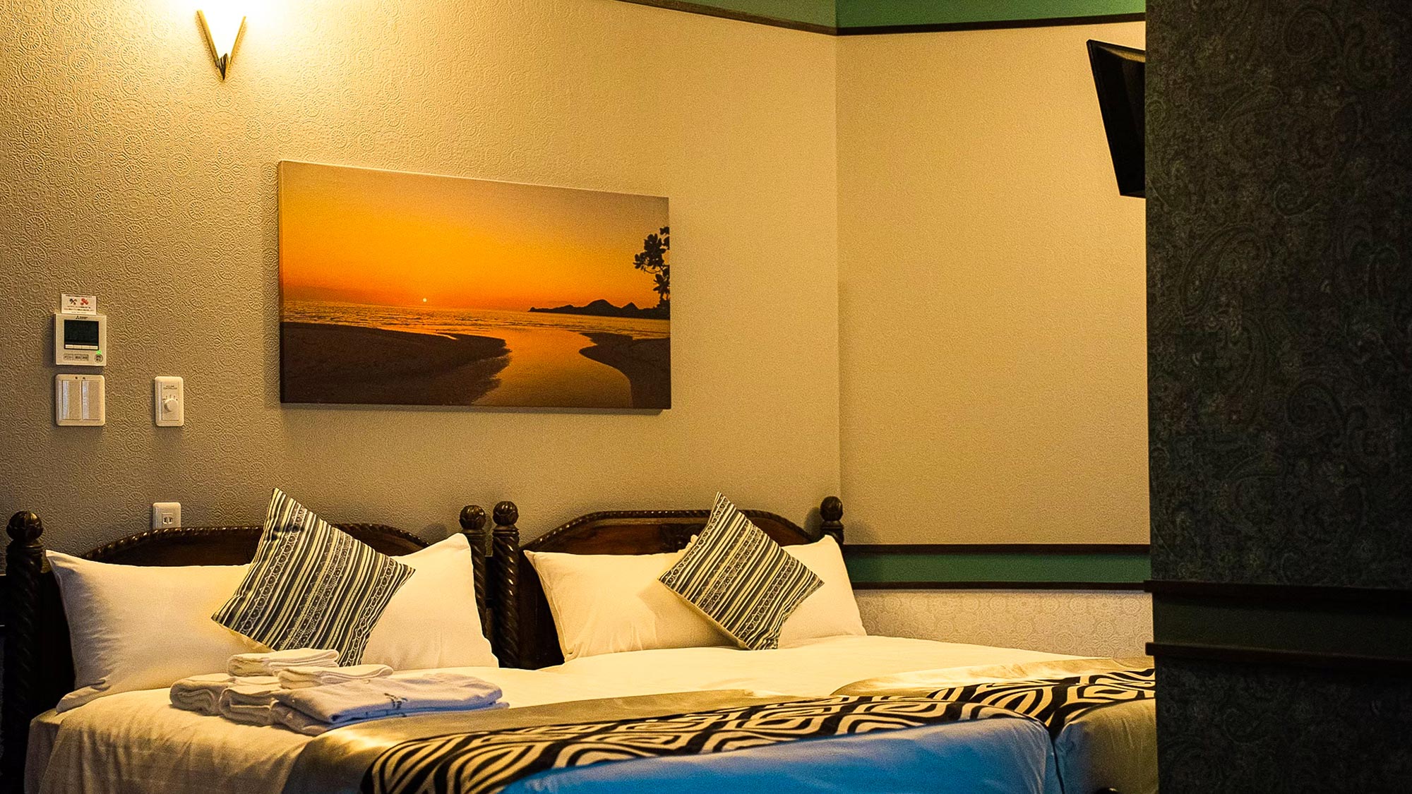 ・【スイートルーム】柔らかな照明と夕日のアートが彩る、落ち着いた雰囲気のお部屋です