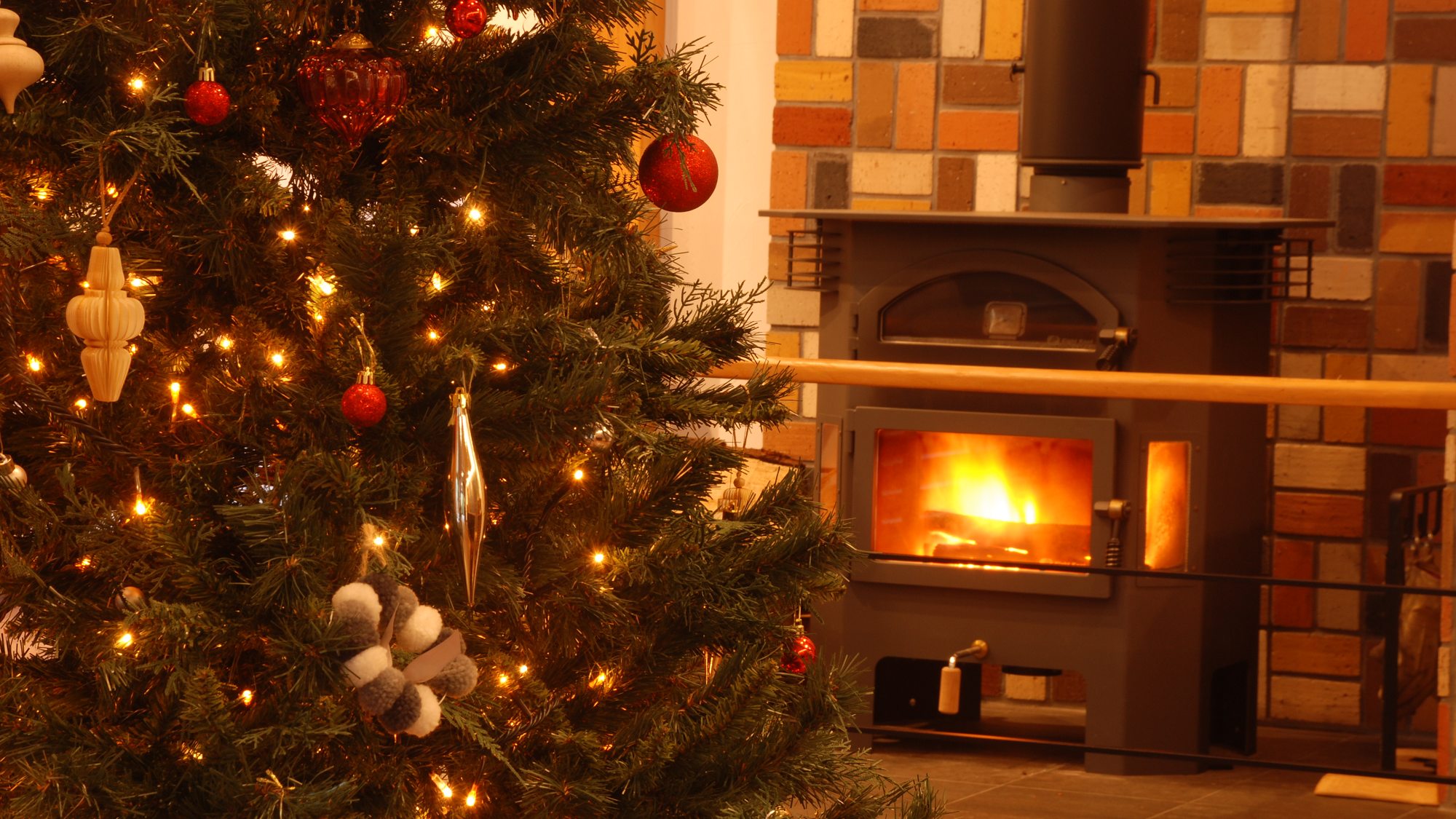 【エントランス】暖かく光るクリスマスツリーと、じんわり芯から温まる薪ストーブ