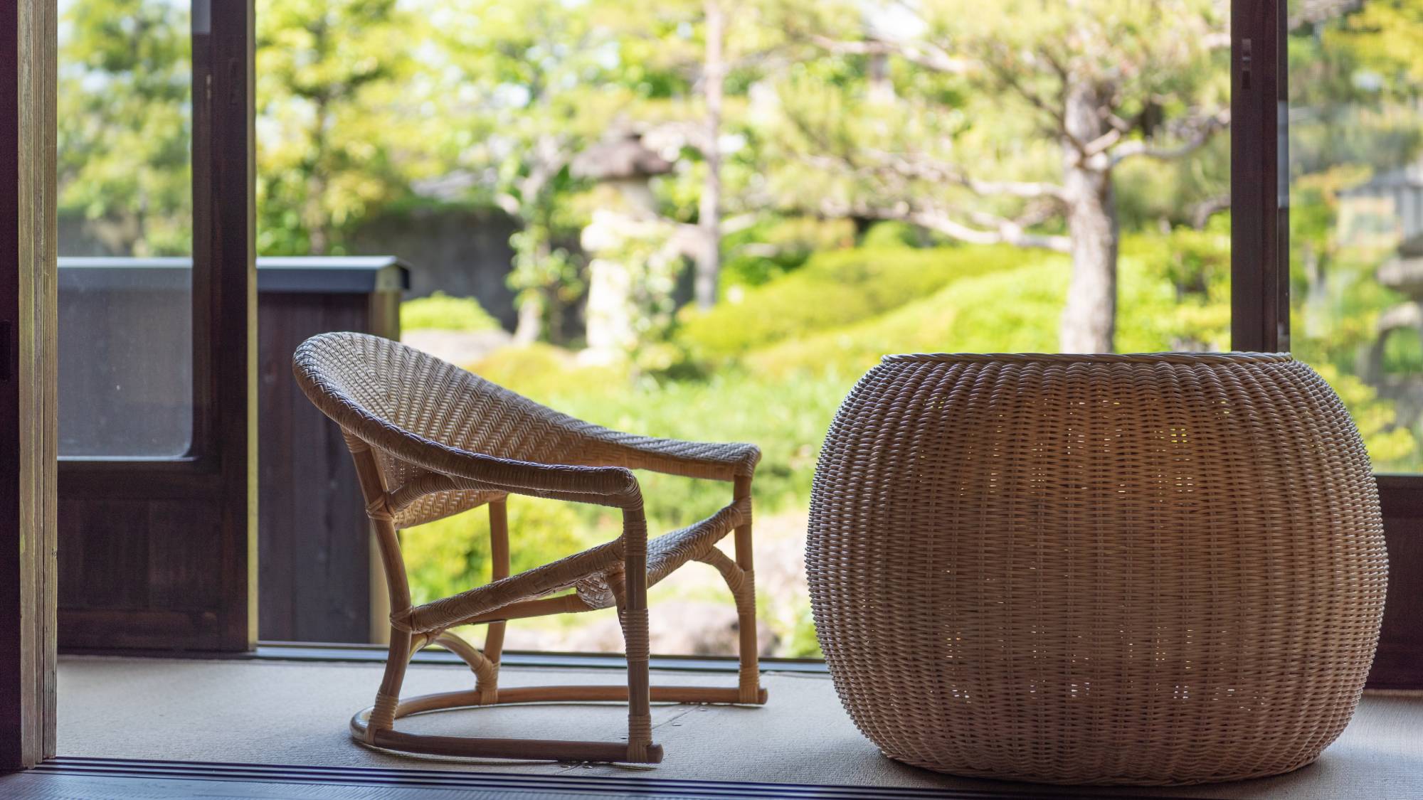 【離れ】お庭の見える窓のそばに籐製の椅子を2脚・ローテーブルを1台設置しております。