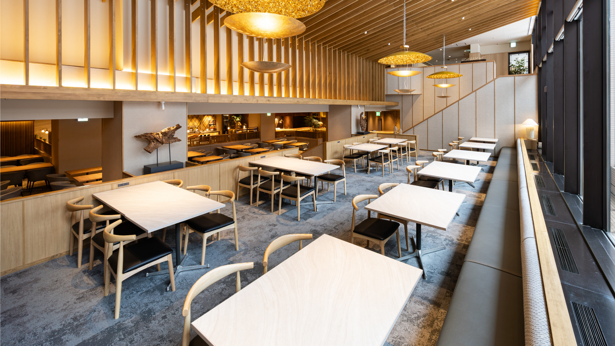 「ザ・ハーバー」客席：木材の温もりに包まれた、落ち着いたレストラン空間。 北海道の風土を感じるアート