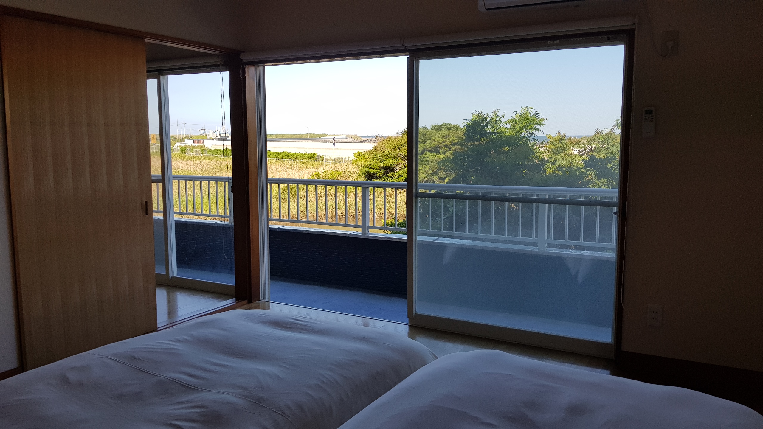 【2F/ベッドルーム】大きなバルコニーと窓からは、オーシャンビューをお楽しみいただけます。