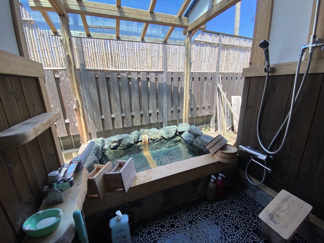 古民家の露天岩風呂。薪で沸かしたやわらかなお湯で、ゆっくり旅の疲れを癒せる。