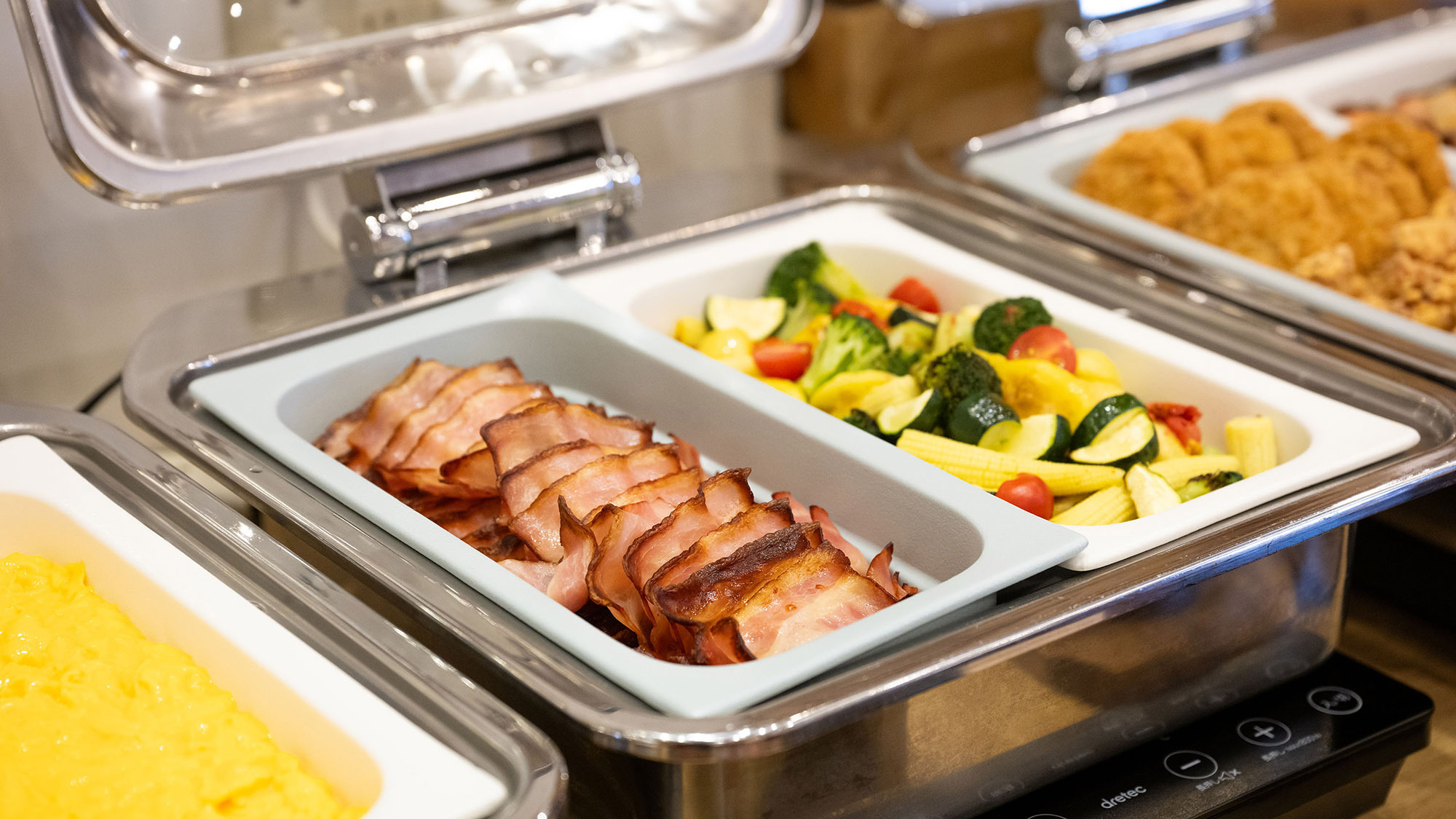 朝食｜温野菜やジューシーなベーコンが並び、朝の食欲を満たす至福のビュッフェです。