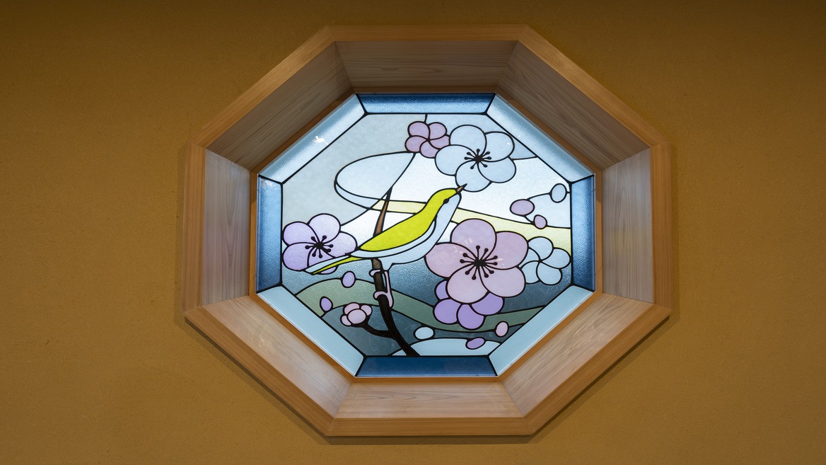 【館内イメージ】入口に梅に鶯(うぐいす)のステンドグラスが飾られております。