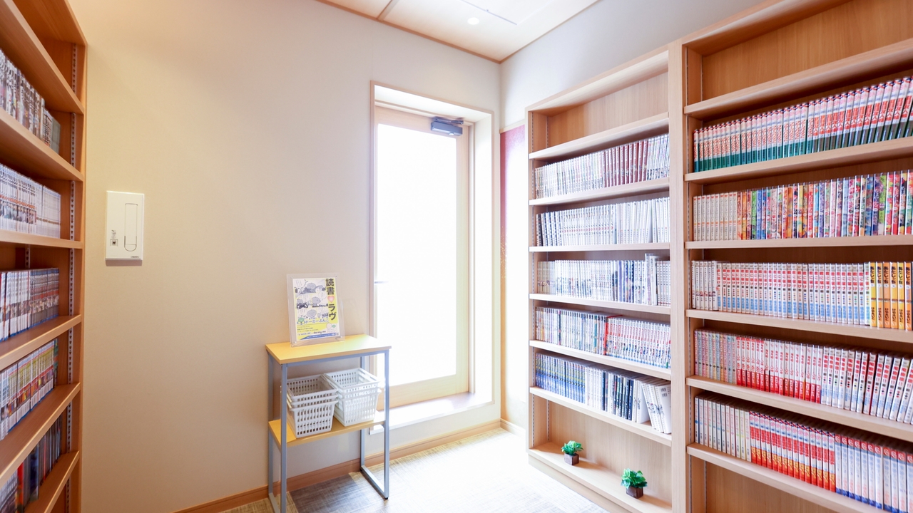 御宿 野乃大阪淀屋橋の漫画コーナー。窓のある小部屋の壁に本棚が並び、漫画がぎっしり入っている