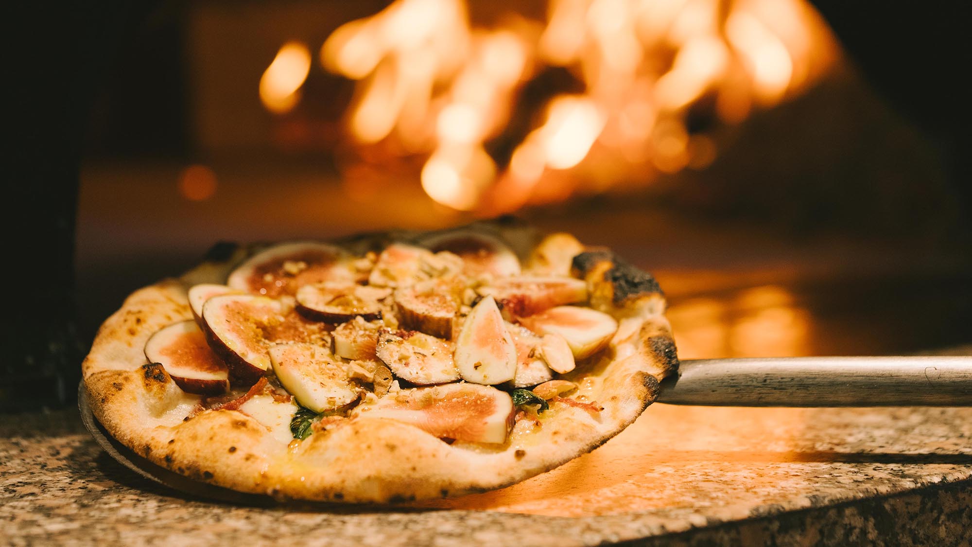 季節のフルーツや野菜をあしらった薪窯焼きの本格派ピッツァ。