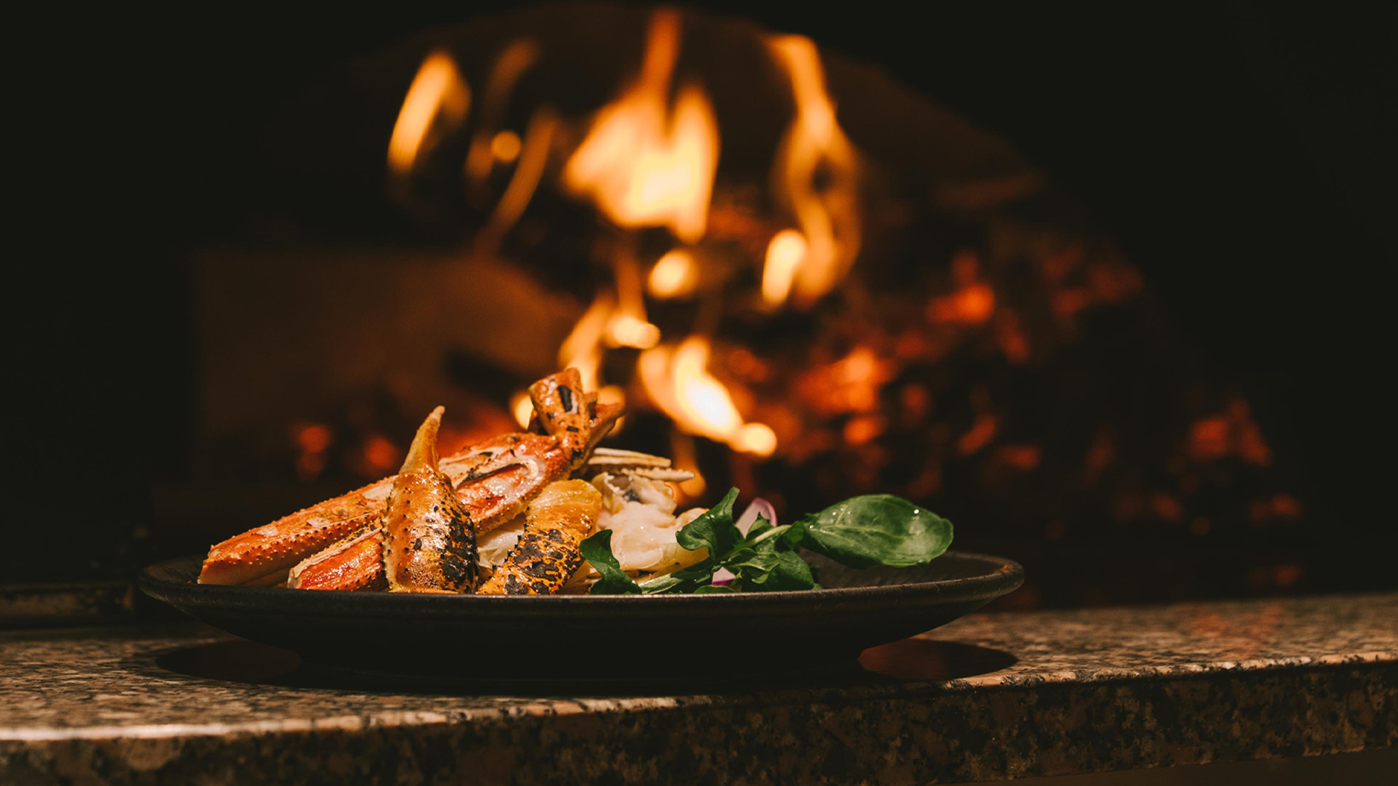 薪火で焼き上げる薪窯焼き蟹。約300度の高温で一気に焼き上げます。