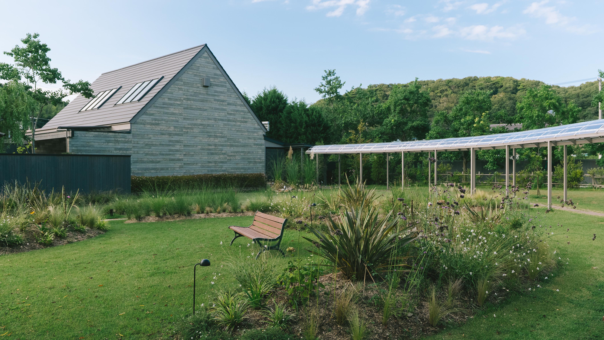 ［温泉棟］ガーデンの奥には三角屋根が特徴的な温泉大浴場。