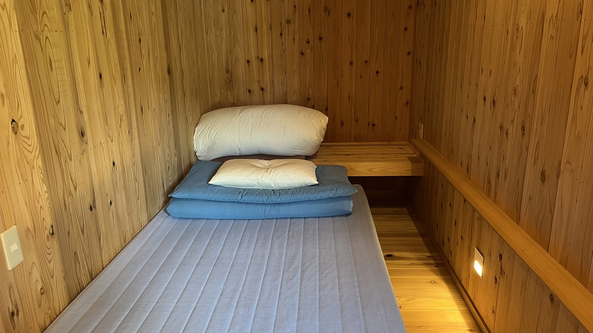 ・【かわせみ：半個室】シングルベッドの半個室。間接照明が木の質感を際立たせる空間です