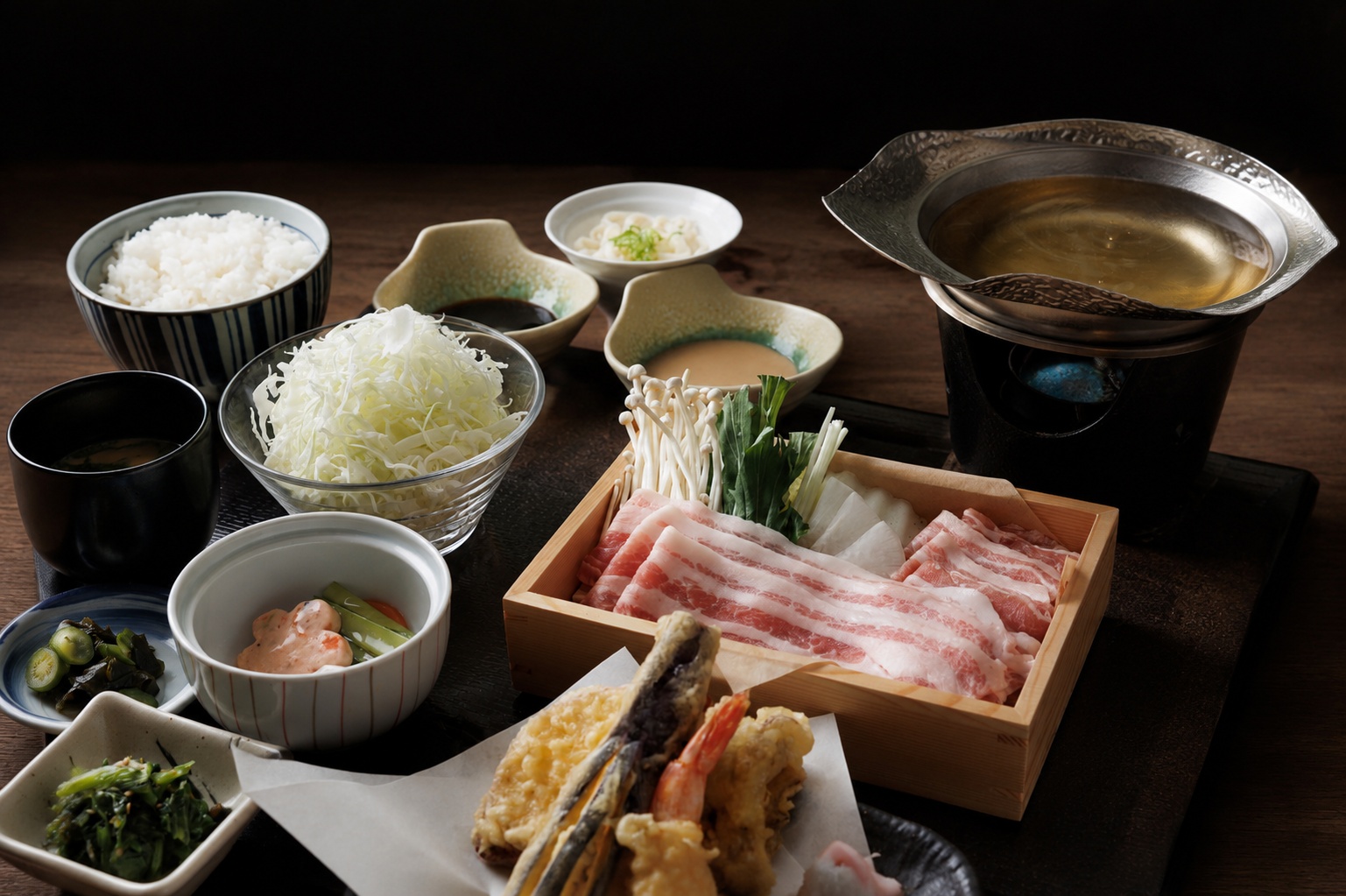 冬桜の宿 神泉の人気夕食「国産ブランド豚のしゃぶしゃぶ御膳」です。やわらかく旨みあふれる国産ブランド豚を、たっぷりのキャベツや旬の野菜とともに特製だしでお召し上がりいただけます。天ぷらや小鉢、ご飯、味噌汁が付いた、彩り豊かな御膳をご用意。素材の美味しさを大切にした、心も満たされる里山の味覚をご堪能ください。