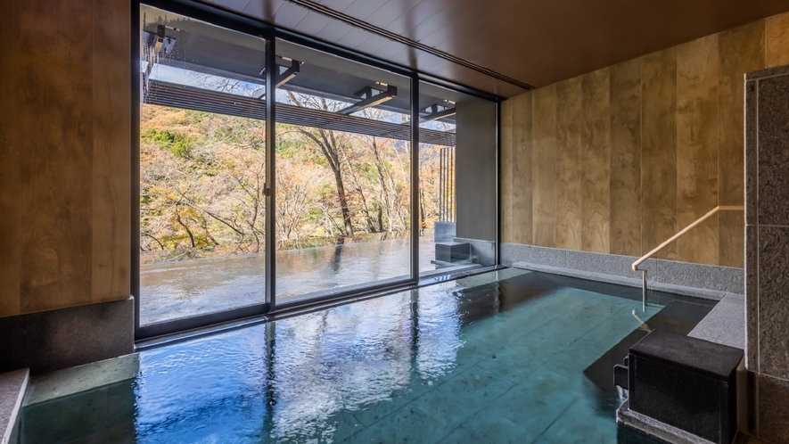 【大浴場】内湯からも外の景色をお楽しみいただける大きな窓ガラスが完備されております。