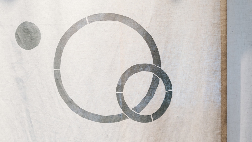 【スタンダードルーム　丸】入り口の暖簾には、部屋名のモチーフとなる丸のマークが描かれています