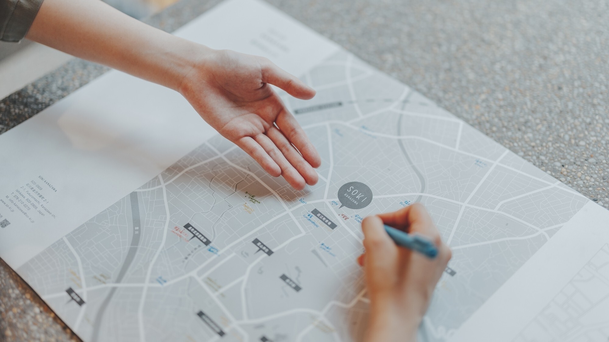 [レセプション]お客様とお話しながら、金沢の白地図におすすめの情報を書き込みお渡しいたします。