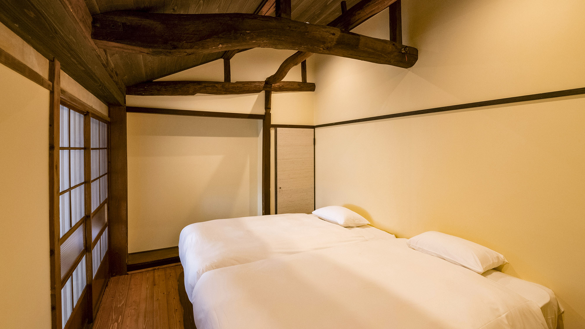 【KOIKE・MIYATANI棟202/客室】寝室の天井には立派な梁。当時の面影を残しています