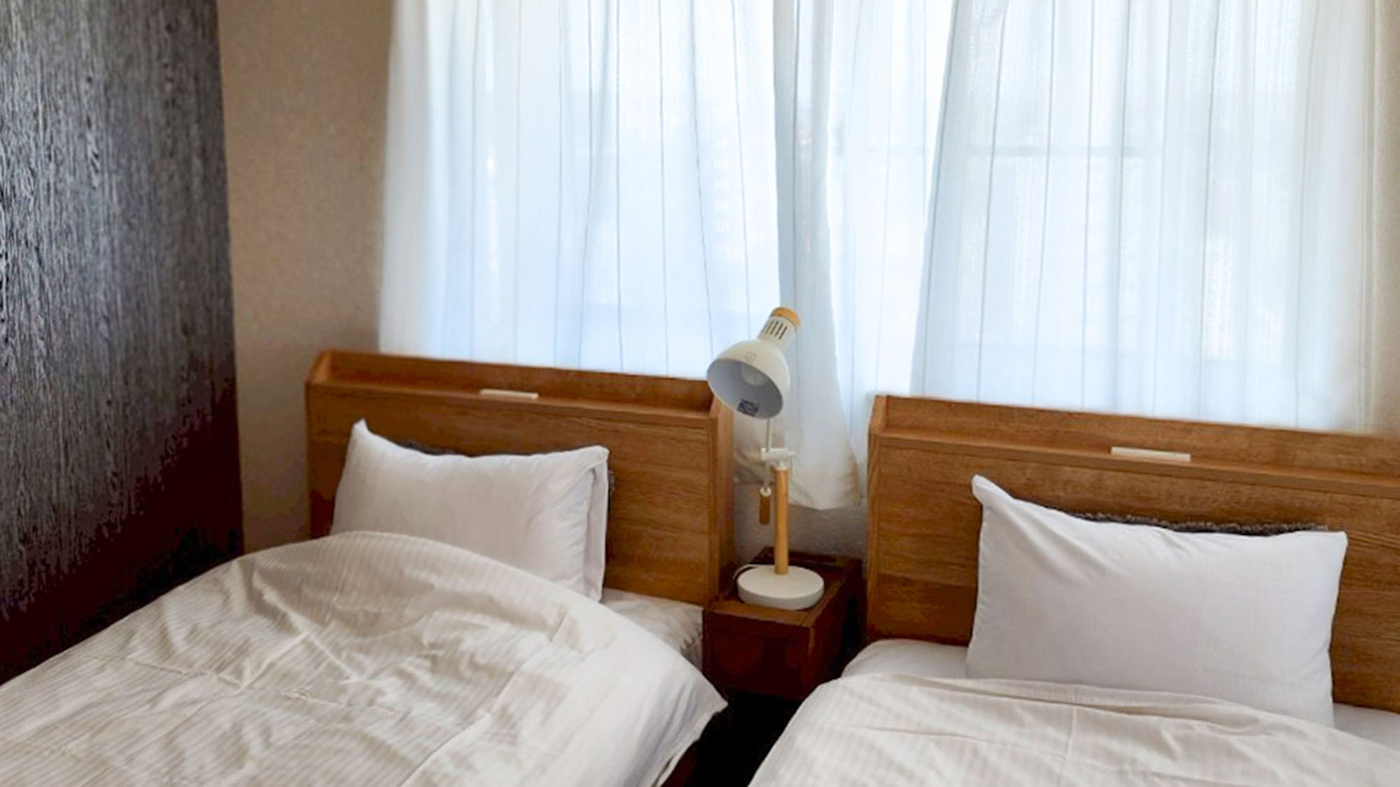 ・【1001：寝室2】木製のヘッドボードを備えたベッド。枕元を照らすライトも備えています