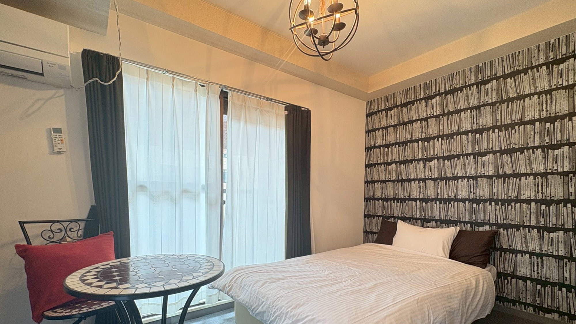 ・【305：寝室1】特徴的な壁紙や照明が目を惹くお部屋。お洒落なテーブルでお食事も可能