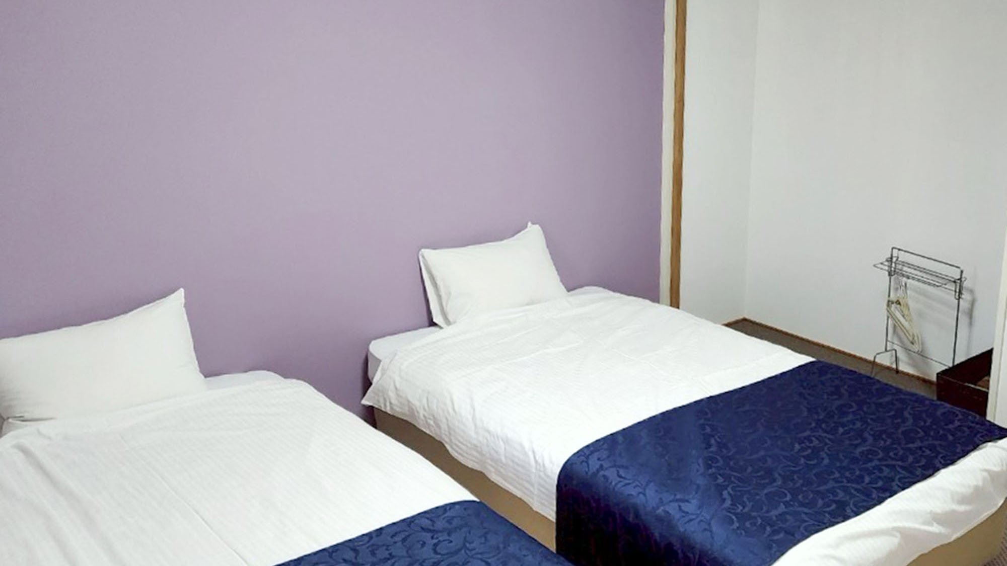 ・【703：寝室】華美な装飾を排除したシンプルな室内。パープルの壁が目をひきます