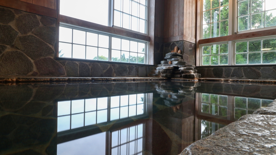 温泉　浴槽と床は鉄平石で作られており、梵字が書かれた姫川薬石がございます。
