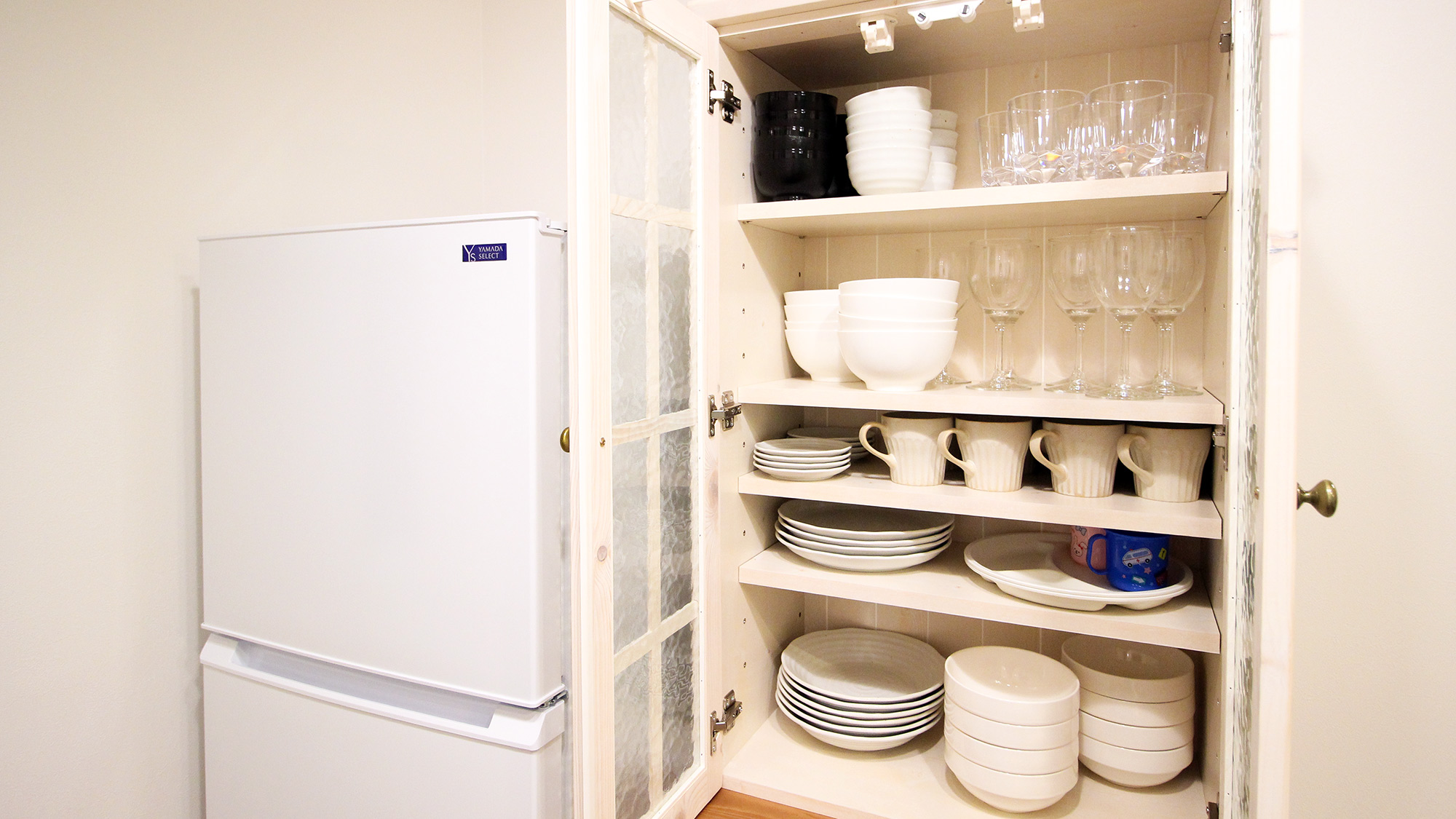 ・【キッチン】冷蔵庫の隣に食器棚を完備。料理やお飲み物の合わせてご自由にご利用ください