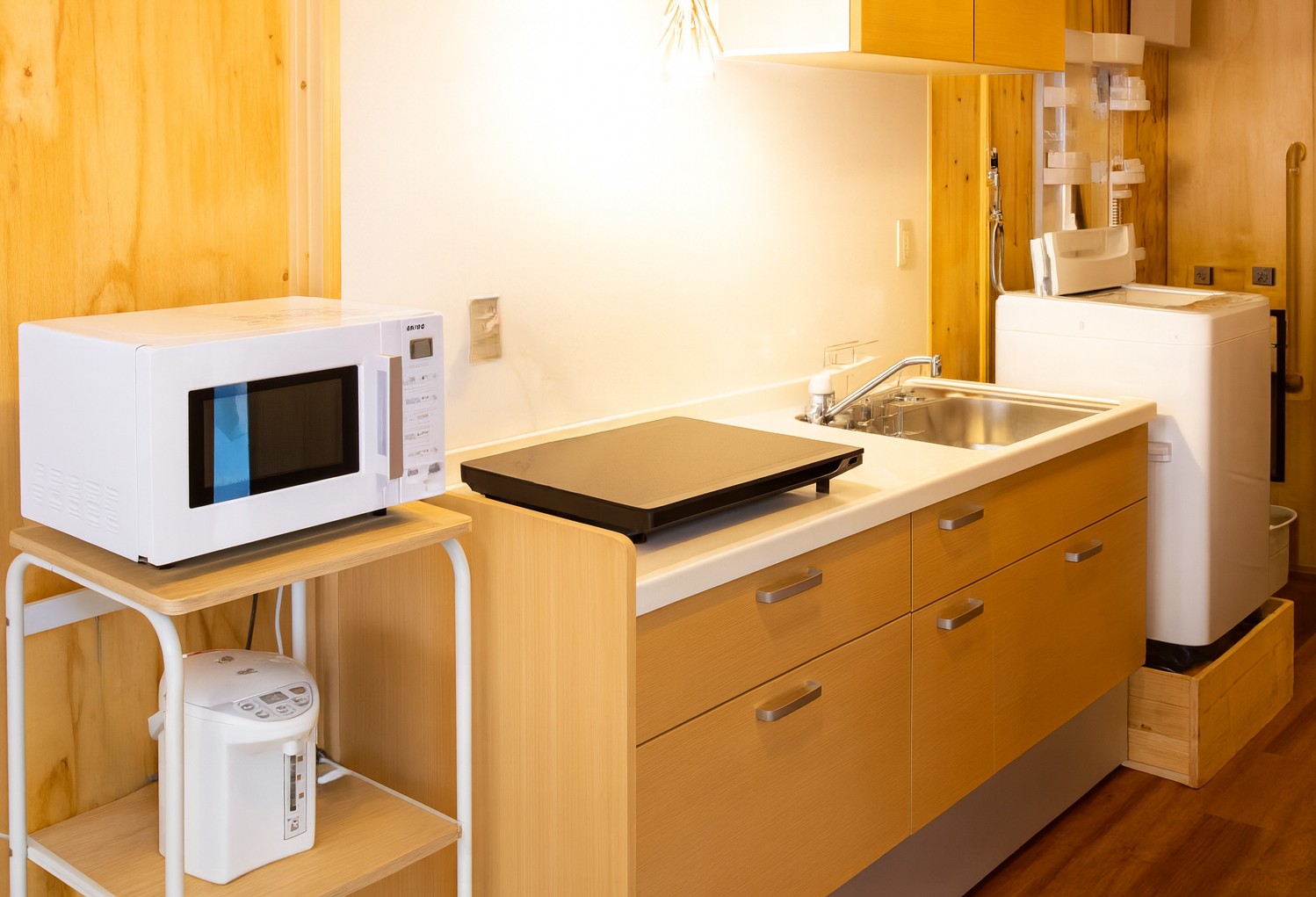 電子レンジやIHコンロ、洗濯機まで揃った、温かみのある木目調の使いやすいキッチン空間