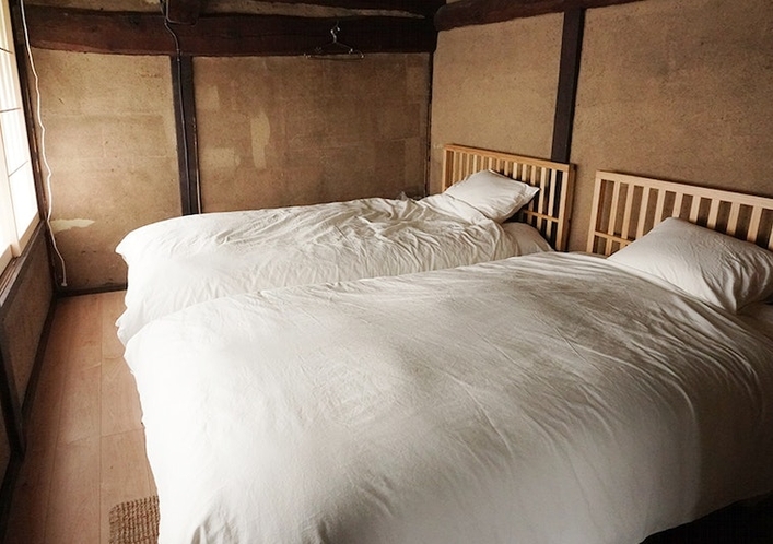 2階寝室です。広めのベッドをご用意致しました。かつてここで絹を織っていたそうです。お部屋
