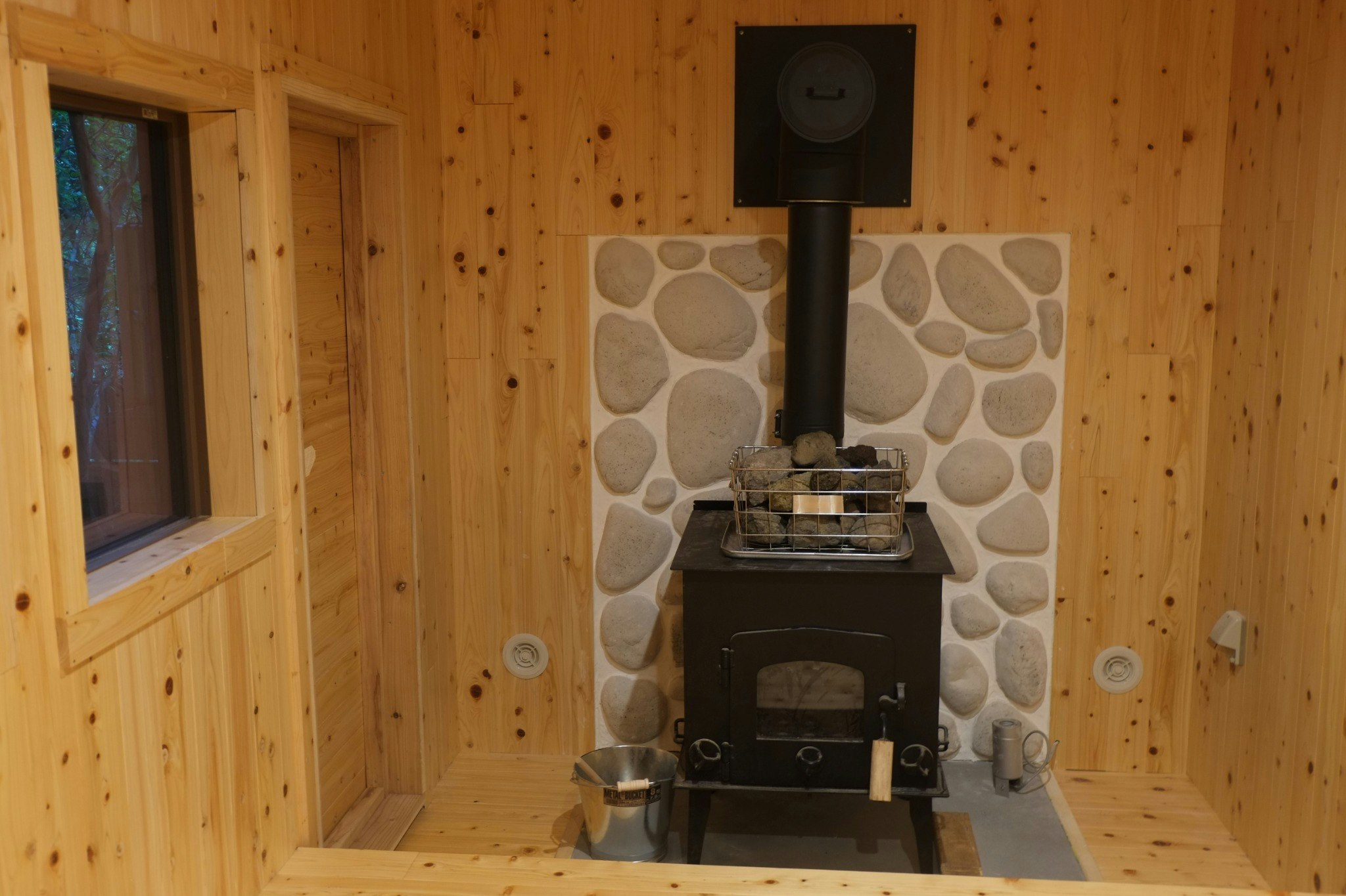 地元の「岡部工業所」に特注製作していただいた大型の薪ストーブ、溶岩石のロウユウもお楽しみください