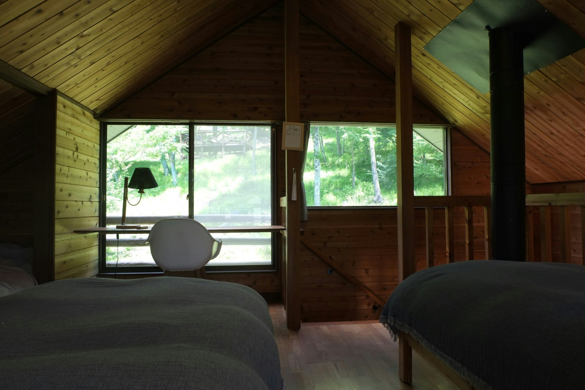 デスクと椅子、窓の外の斜面に鹿がよく姿を現します