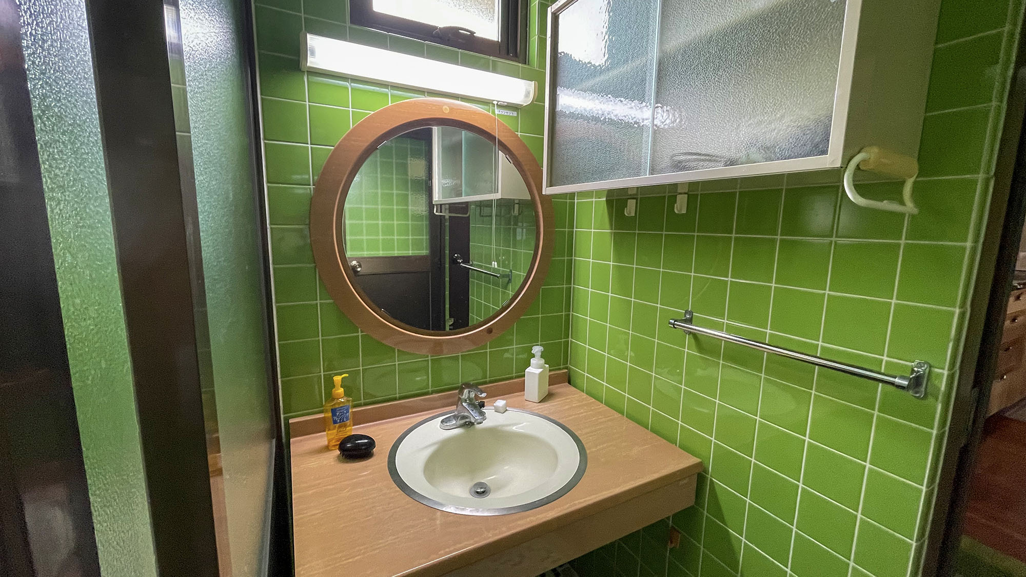 ・明るい緑のタイルを基調とした清潔感のある洗面台