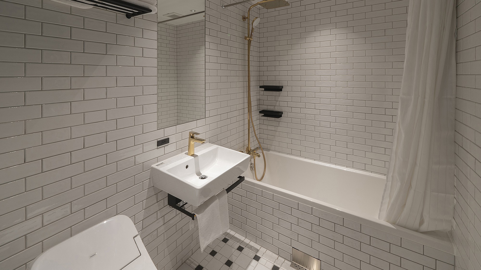 【デラックスクイーン】白いタイル張りのスタイリッシュな造りのバスルーム。