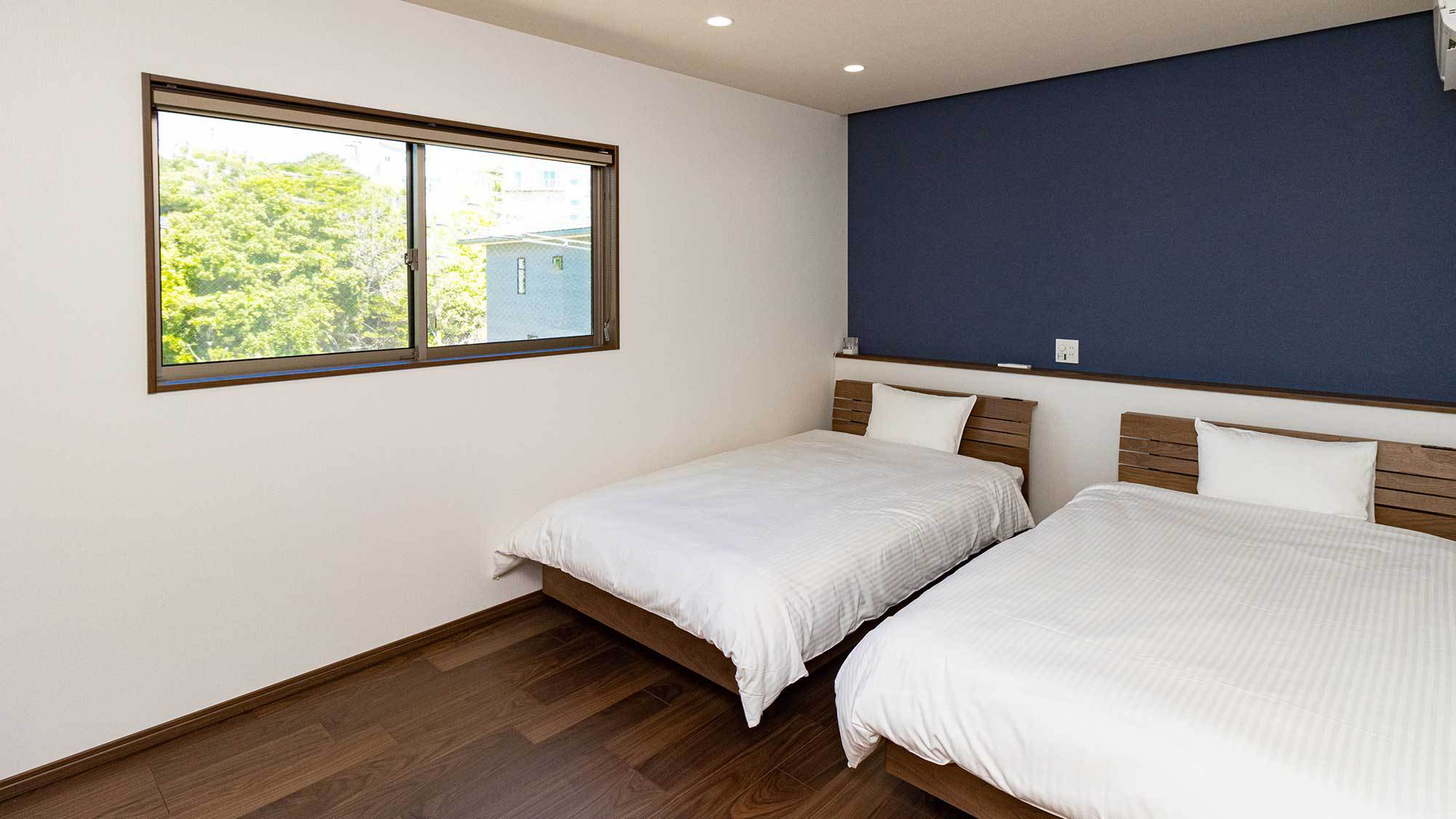 ・【洋室ベッドルーム】濃紺と白を基調としたシンプルなインテリア